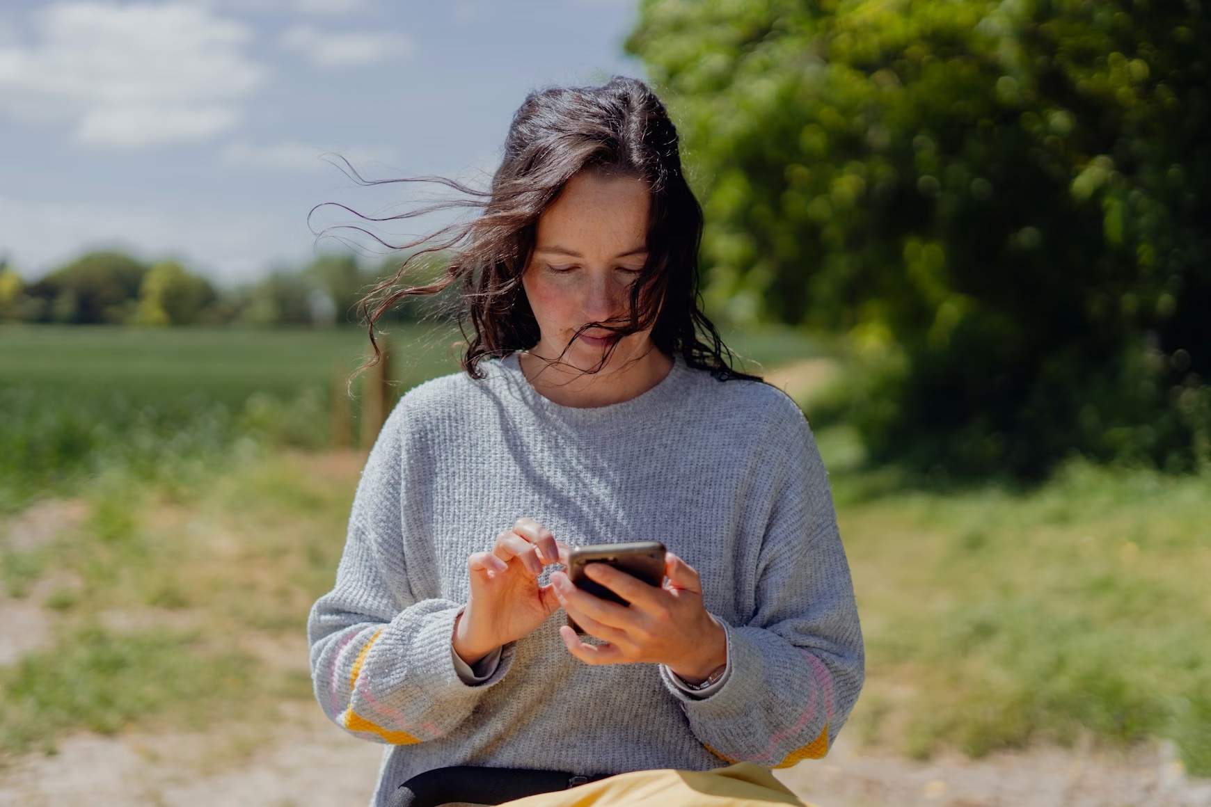 A person using the Geo-Quest app in a grassland